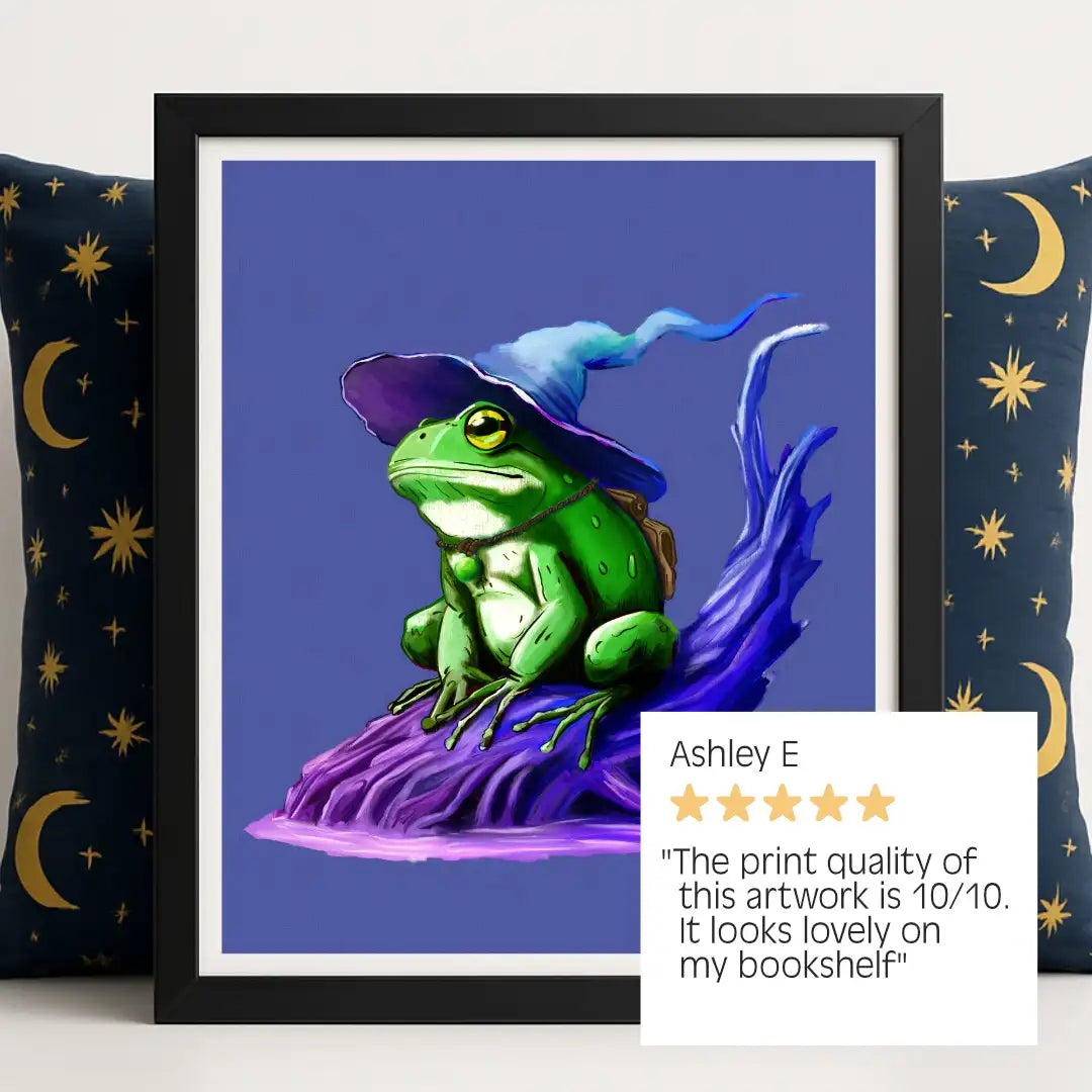 Wizarding Frog Fantasy Print framed in sleek black, styled against a navy 90s celestial pillow and accompanied by a glowing 5-star review: ‘10/10, the print quality is amazing and this artwork looks fab framed on my bookshelf."