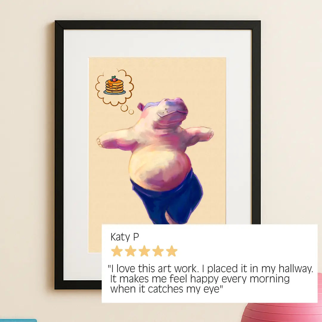 “Hippo Yoga Tree Pose Print in sleek black frame, hung in a home yoga studio with a glowing customer review: ‘I love this artwork. It makes me feel happy every morning when it catches my eye."