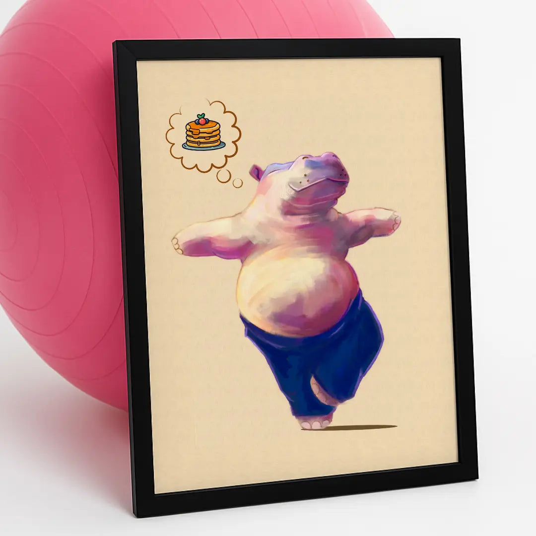 Sleek black frame with Hippo Yoga Tree Pose Print, styled against a pink yoga ball on a clean white background — quirky handmade eco-art for wellness lovers. This quirky illustration is of a happy pink hippo doing their favourite yoga pose (tree pose), while thinking positive thoughts of pancakes for breakfast.