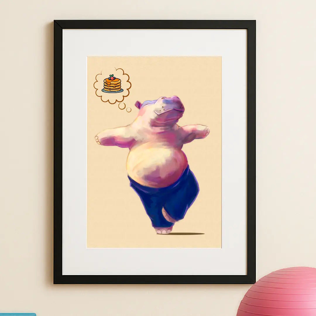 “Close-up of Hippo Yoga Tree Pose Print in sleek black frame, hung in a home yoga studio with yoga equipment in view — handmade eco art capturing wellness and positivity. This quirky illustration is of a happy pink hippo doing their favourite yoga pose (tree pose) while thinking positive thoughts of pancakes for breakfast.